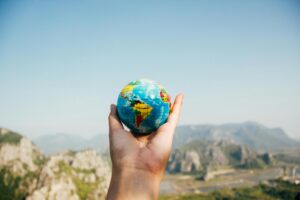 Traveler holding a small globe with mountains in the background